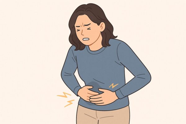 배를 부여잡고 더부룩함을 느끼는 여성
